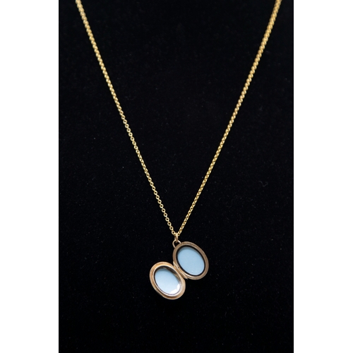 42 - A vintage 9ct gold small oval locket and chain, the locket part foliate engraved and with hallmarks ... 