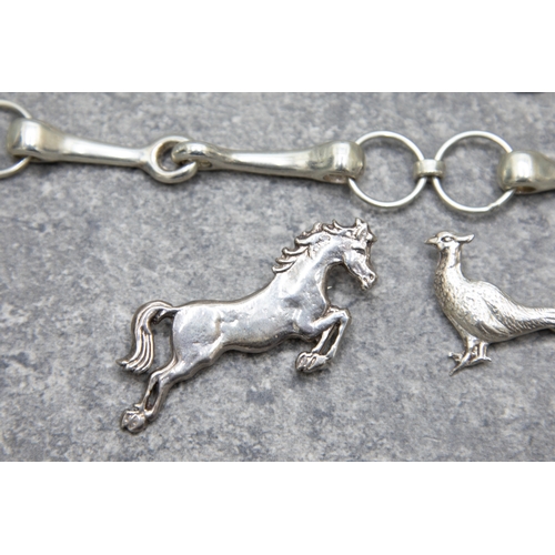 67 - A group of silver equestrian jewellery and a pheasant brooch, Comprising; a jumping pony; two race h... 