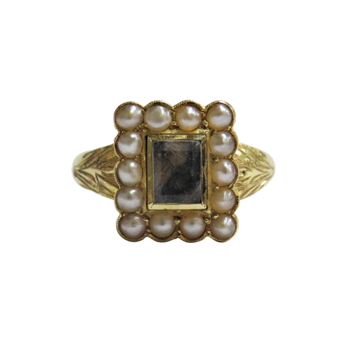 33 - An early 20th century gold and half-pearl mourning ring, the rectangular head with a central glazed ... 