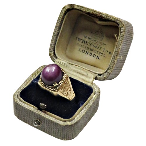 36 - A vintage gold and oval 'star' ruby single stone ring, the purple / red cabochon displays a weak sta... 