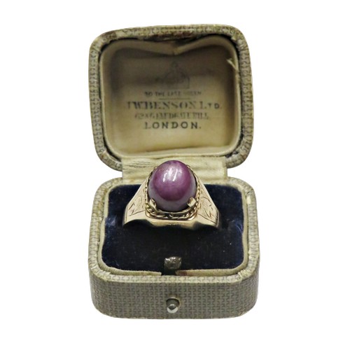 36 - A vintage gold and oval 'star' ruby single stone ring, the purple / red cabochon displays a weak sta... 