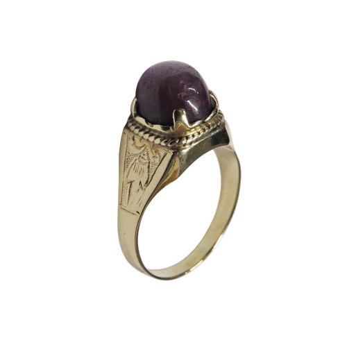 36 - A vintage gold and oval 'star' ruby single stone ring, the purple / red cabochon displays a weak sta... 