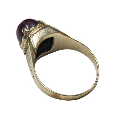 36 - A vintage gold and oval 'star' ruby single stone ring, the purple / red cabochon displays a weak sta... 