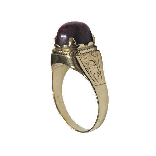 36 - A vintage gold and oval 'star' ruby single stone ring, the purple / red cabochon displays a weak sta... 