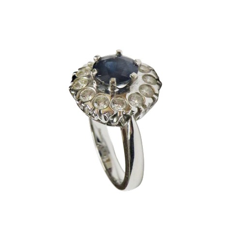 50 - An 18ct white gold, sapphire and diamond cluster ring, centred with a round mixed-cut sapphire appro... 