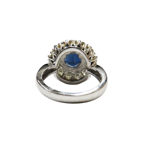 50 - An 18ct white gold, sapphire and diamond cluster ring, centred with a round mixed-cut sapphire appro... 