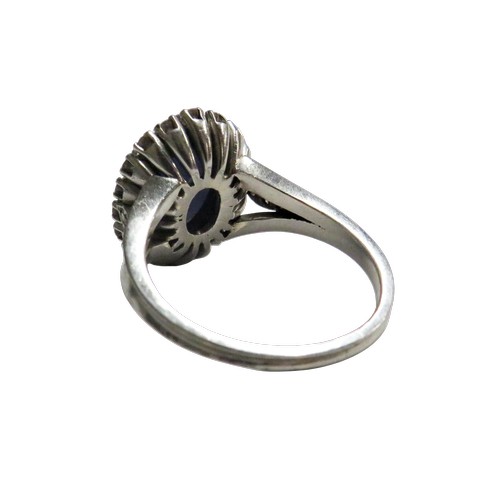 59 - A vintage platinum, 'star' sapphire and diamond oval cluster ring, the grey-ish blue oval cabochon d... 