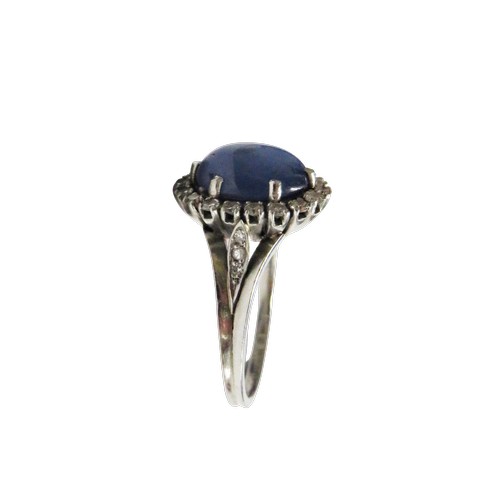 59 - A vintage platinum, 'star' sapphire and diamond oval cluster ring, the grey-ish blue oval cabochon d... 