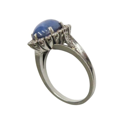 59 - A vintage platinum, 'star' sapphire and diamond oval cluster ring, the grey-ish blue oval cabochon d... 