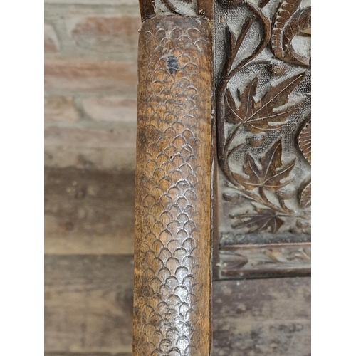 1023 - 19th century Anglo Indian armchair, profusely carved with  pierced floral detail, raised on turned s... 