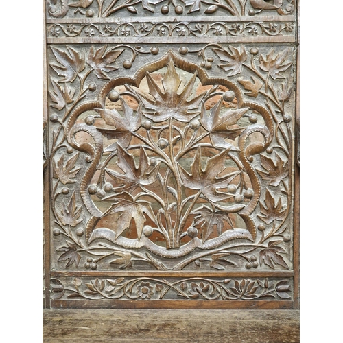 1023 - 19th century Anglo Indian armchair, profusely carved with  pierced floral detail, raised on turned s... 