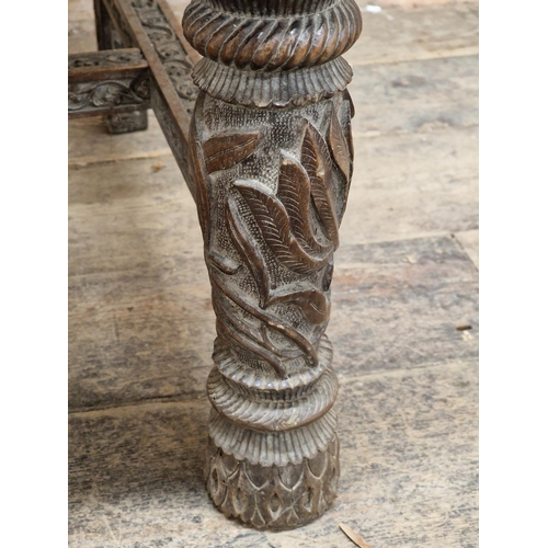1023 - 19th century Anglo Indian armchair, profusely carved with  pierced floral detail, raised on turned s... 