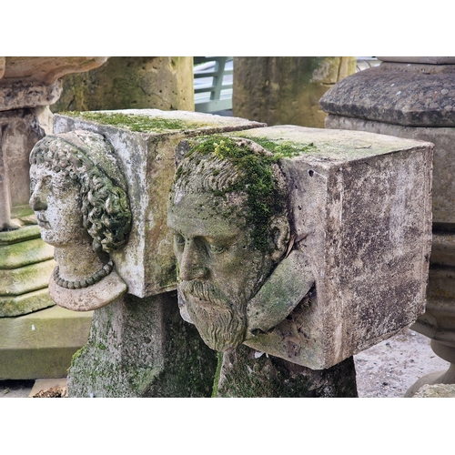 14 - Two weathered reconstituted stone male and female face mask corbels, H 32cm x W 28cm x D 35cm (2)
