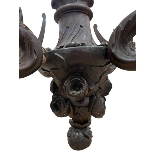 30 - A large early 20th century Swiss Black Forest carved wooden four-arm electrolier, the branches model... 
