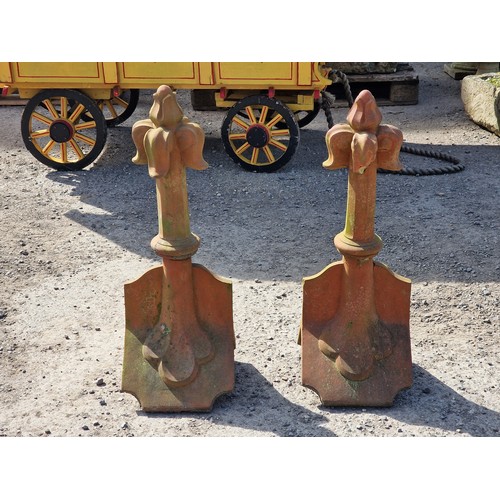 128 - Pair of terracotta roof tiles with fleur-de-lis finials, H 68cm x W 32cm x D 26cm (2) (one finial ha... 