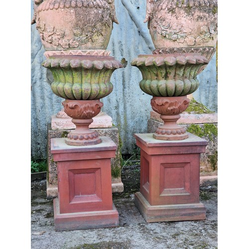 135 - Pair of antique terracotta effect garden urns with lobed bowls and spiked rims, raised on octagonal ... 