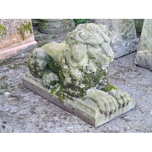147 - Weathered reconstituted stone statue of a recumbent lion, H 51cm x W 82cm x D 31cm