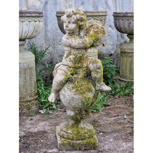 158 - Well weathered reconstituted stone garden statue of a musical cherub seated on a ball pier cap playi... 