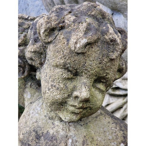155 - Weathered reconstituted stone garden statue of a seated cherub clutching a bundle of flowers, H 76cm... 
