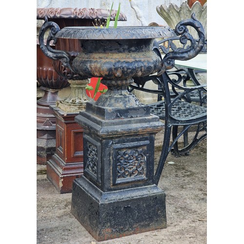174 - Antique painted cast iron urn with ornate scrolled handles and lobed bowl, raised on a square plinth... 