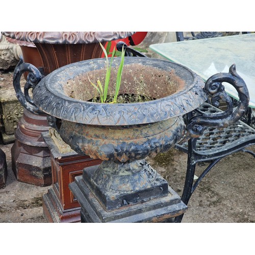 174 - Antique painted cast iron urn with ornate scrolled handles and lobed bowl, raised on a square plinth... 