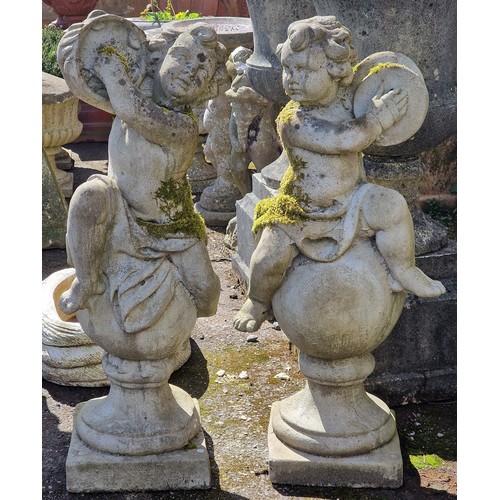 159 - Pair of weathered reconstituted stone garden statues of musical cherubs seated on ball pier caps, on... 