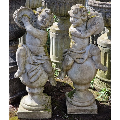 160 - Pair of weathered reconstituted stone garden statues of musical cherubs seated on ball pier caps, on... 