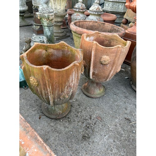 131 - Pair of two sectional terracotta urns with textured roundels and incised detail,