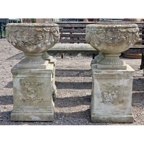 4 - Haddonstone - Pair of reconstituted stone garden urns with ornate foliate swag relief, raised on squ... 