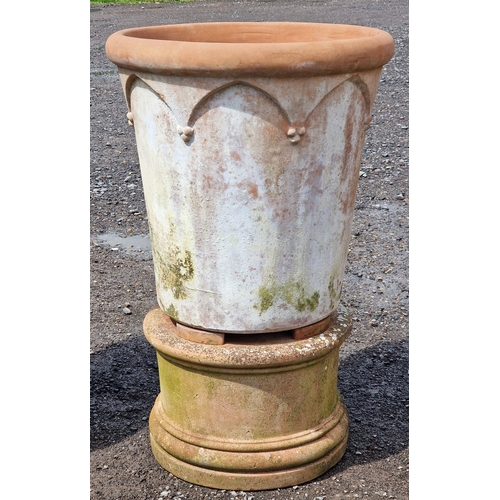 9 - Three large Italian terracotta planters with Gothic arch detail raised on circular terracotta plinth... 