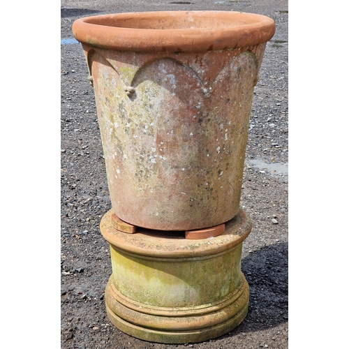 9 - Three large Italian terracotta planters with Gothic arch detail raised on circular terracotta plinth... 