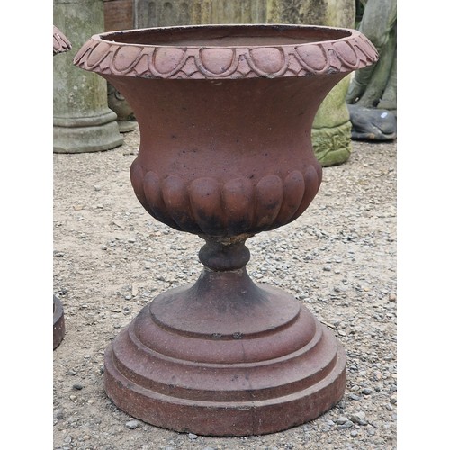 31 - Pair of salt glazed terracotta urns with lobed bowls and flared darted rims, raised on stepped circu... 