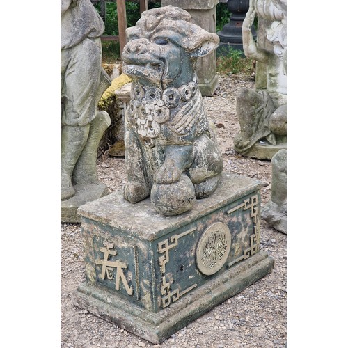 33 - Reconstituted stone statue of a Foo dog raised on a plinth with gilded relief, H 80cm x W 33cm x D 5... 