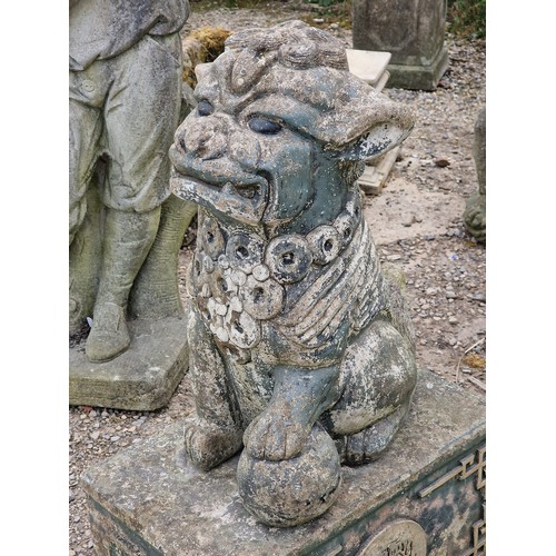 33 - Reconstituted stone statue of a Foo dog raised on a plinth with gilded relief, H 80cm x W 33cm x D 5... 