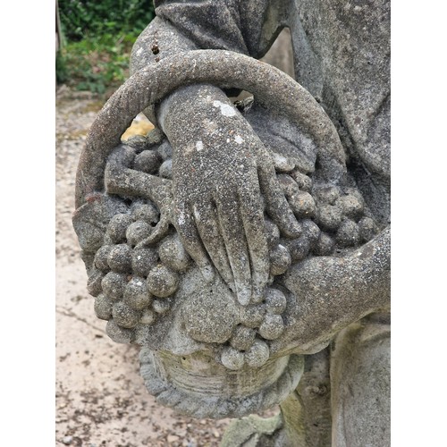 35 - Haddonstone - Weathered reconstituted stone statue of a boy holding a basket of grapes, H 117cm x W ... 