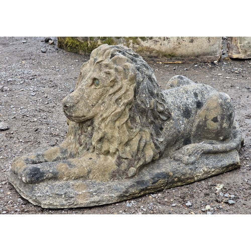 40 - Reconstituted stone recumbent lion statue with glass eyes, H 36cm x W 32cm x D 74cm