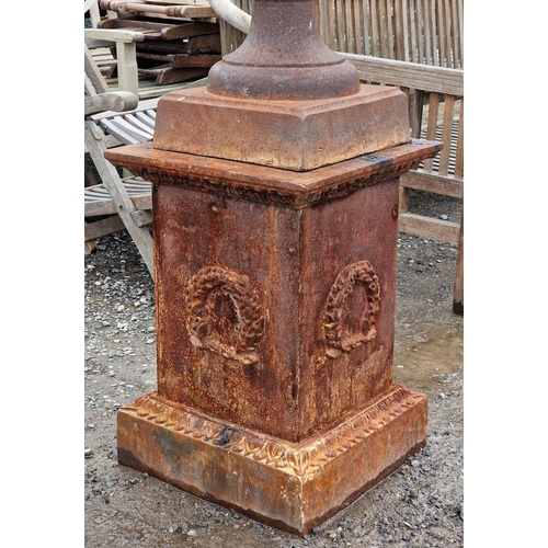 44 - Large cast iron Campana urn with lobed bowl and winged cherub relief, raised on a square cut plinth ... 