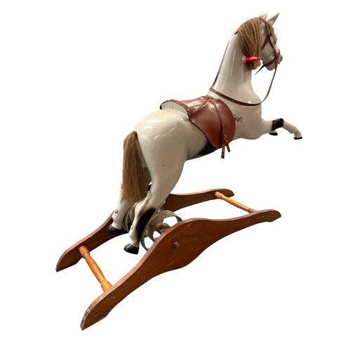 53 - Fairground interest - A Mid 20th Century painted fibreglass and wooden rocking horse, with iron spru... 