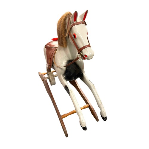 53 - Fairground interest - A Mid 20th Century painted fibreglass and wooden rocking horse, with iron spru... 