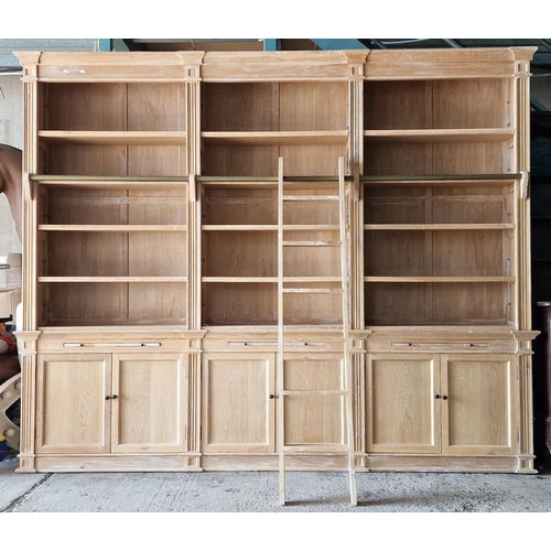 Monumental contemporary light oak two sectional bookcase fitted with an array of shelves and cupboards, complete with library ladder, H 241cm x W 298cm x D 40cm