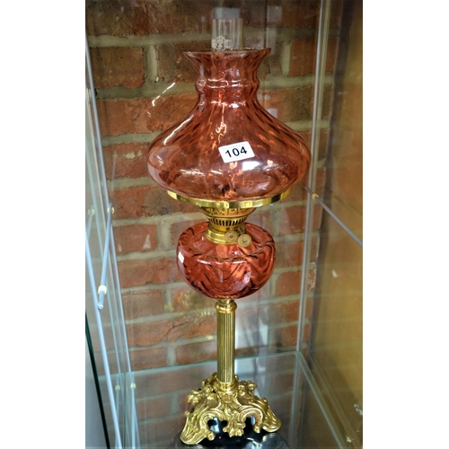 104 - Ruby glass and brass column oil lamp