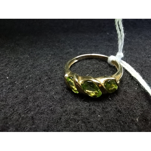 453 - 9ct yellow gold ring size P oval green centre stone flanked by 2 offset oval smaller green stones