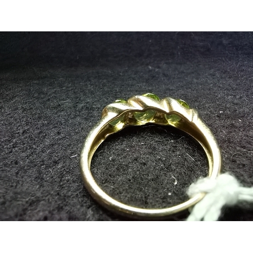 453 - 9ct yellow gold ring size P oval green centre stone flanked by 2 offset oval smaller green stones