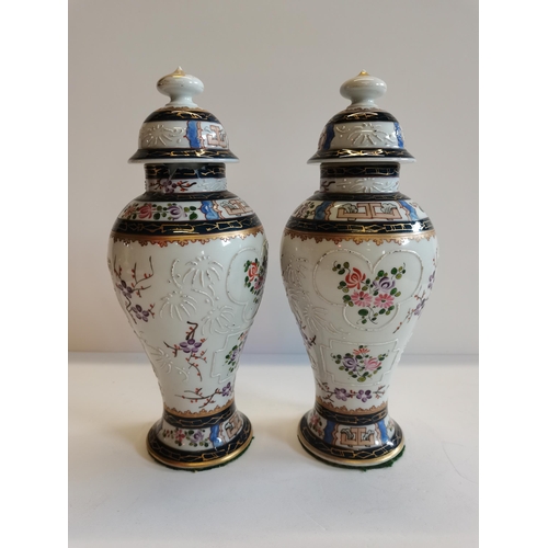 158 - A pair of Porcelain vases in Chinese Export style. Lid on one of the vases has a couple of chips