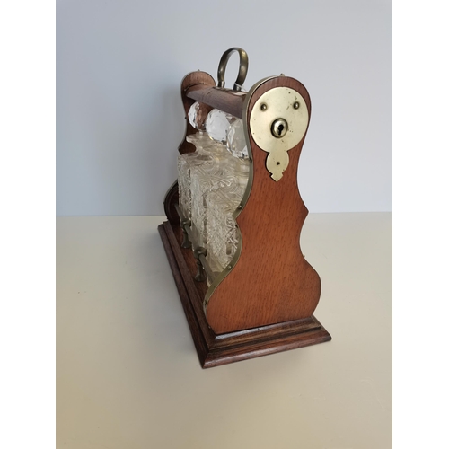 59 - Wooden Tantalus with key - brass detailing and 3 cut glass decanters