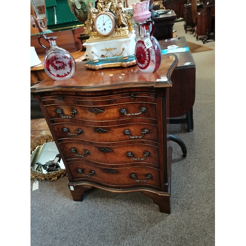 597 - Walnut and mahogany serpentine front bachelors chest having brush slide above four graduated drawers... 