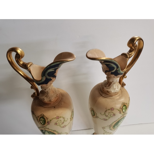 166 - A pair of Crown Devon claret jugs with cherub decoration 45cm high ex condition