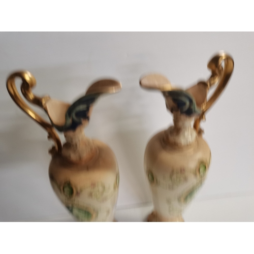 166 - A pair of Crown Devon claret jugs with cherub decoration 45cm high ex condition