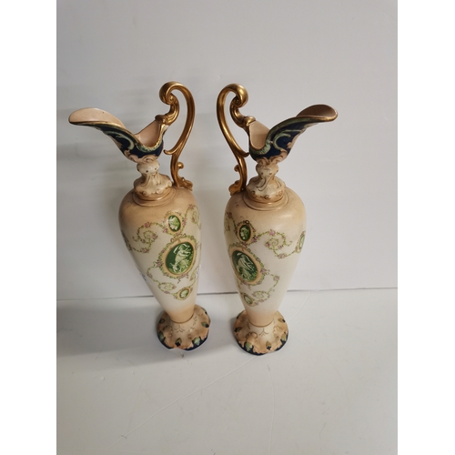 166 - A pair of Crown Devon claret jugs with cherub decoration 45cm high ex condition