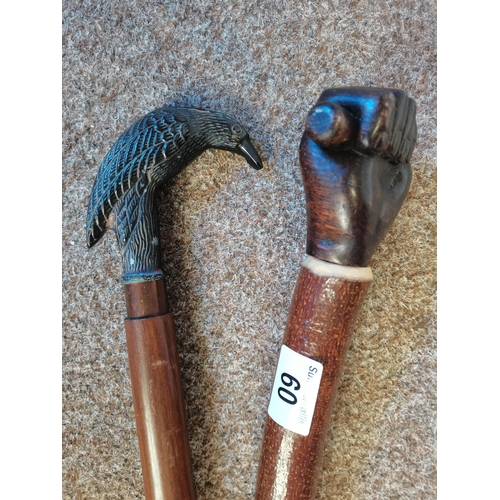 60 - x2 Walking sticks one with a bird head and other with a clenched fist